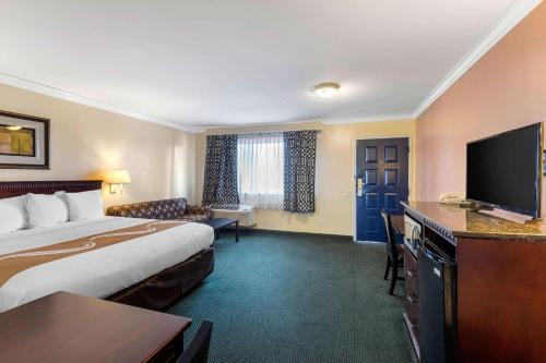 a hotel room with a bed and a flat screen tv at Quality Inn Lomita-Los Angeles South Bay in Lomita
