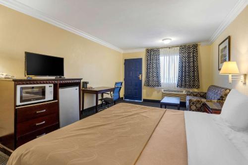 a hotel room with a bed and a desk and a television at Quality Inn Lomita-Los Angeles South Bay in Lomita