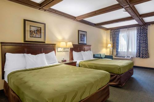 a hotel room with two beds and a chair at Quality Inn Lomita-Los Angeles South Bay in Lomita