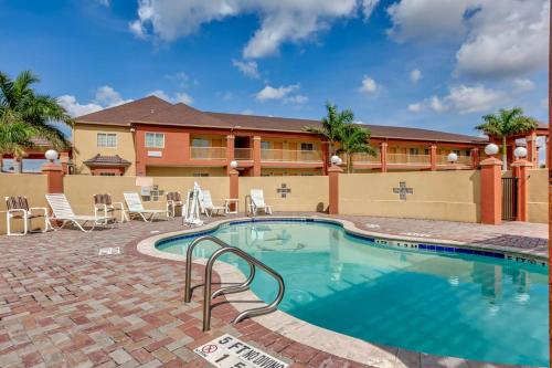 a swimming pool at a resort with chairs and a building at Quality Inn Brownsville in Brownsville