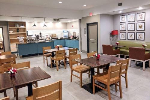 ein Restaurant mit Tischen und Stühlen und eine Küche in der Unterkunft Comfort Inn & Suites in Slidell