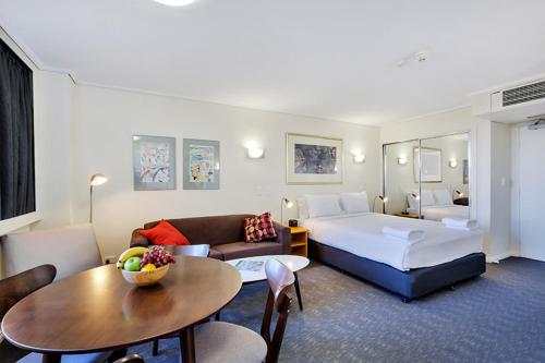 a hotel room with a bed and a table at Cosmopolitan apartment at College St in Sydney