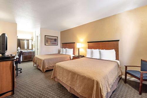 a hotel room with two beds and a television at Rodeway Inn at Nevada State Capitol Carson City in Carson City