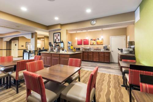 a restaurant with tables and chairs and a kitchen at Comfort Suites Atlantic City North in Absecon
