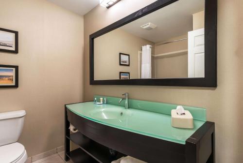 a bathroom with a sink and a toilet and a mirror at Comfort Suites Atlantic City North in Absecon