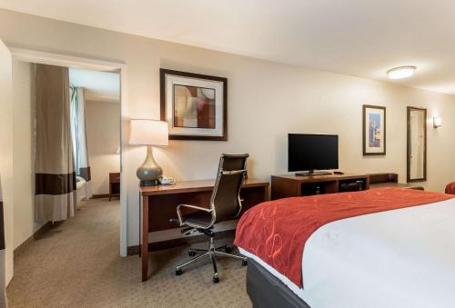 a hotel room with a bed and a desk with a computer at Comfort Suites Atlantic City North in Absecon