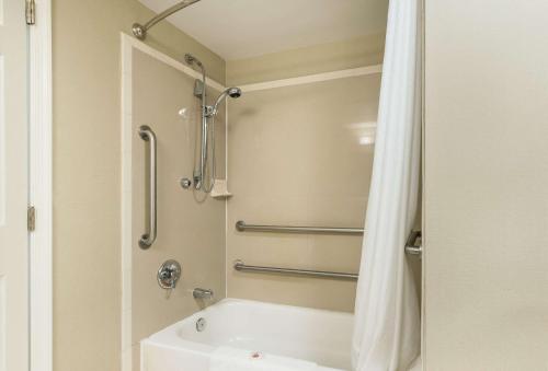 a bathroom with a shower and a white tub at Comfort Suites Atlantic City North in Absecon