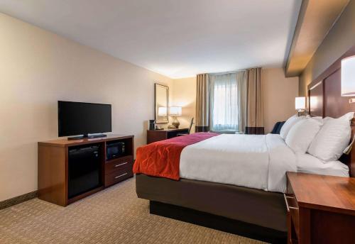 a hotel room with a bed and a flat screen tv at Comfort Suites Atlantic City North in Absecon