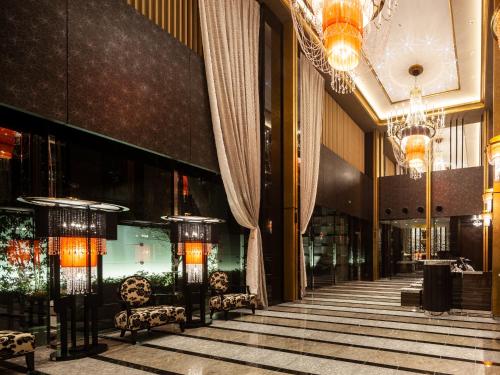 a lobby with chandeliers and chairs in a building at APA Hotel Pride Akasaka Kokkaigijidomae in Tokyo