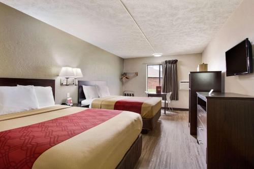 a hotel room with two beds and a flat screen tv at Red Lion Inn & Suites Olathe Kansas City in Olathe