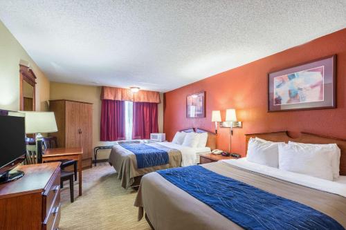 a hotel room with two beds and a flat screen tv at Quality Inn Scottsbluff in Scottsbluff