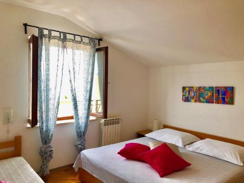 - une chambre avec 2 lits et une fenêtre dans l'établissement Apartments Petricic with swimming pool, à Ičići
