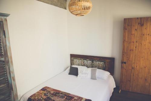 a bedroom with a white bed and a wooden door at The Iskemleci Guest House in North Nicosia