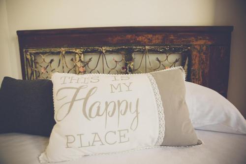 a pillow that says this is my happy place on a bed at The Iskemleci Guest House in North Nicosia