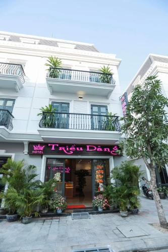a white building with a pink sign on it at Khách sạn Triều Dâng in Tuy Hoa