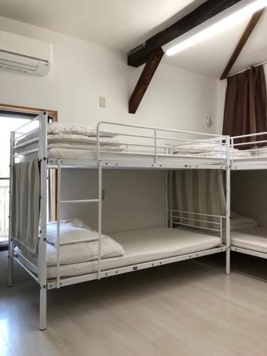 kilka łóżek piętrowych w pokoju w obiekcie Keys House w Tokio
