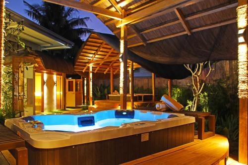 - un bain à remous sur une terrasse avec un parasol dans l'établissement Balai Princesa, à Puerto Princesa