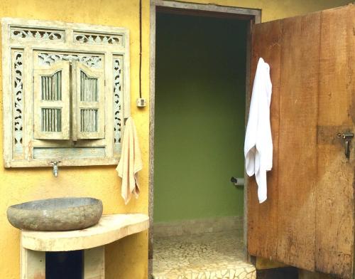 a bathroom with a stone sink next to a door at Bali Mountain Retreat in Selemadeg
