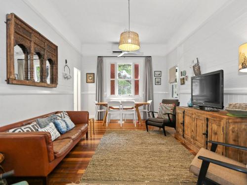 a living room with a couch and a tv at Beluso in Byron Bay