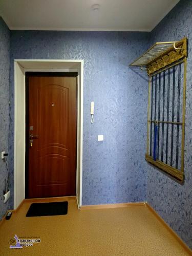 ステルリタマクにあるАпартаменты "Квартирный вопрос" на Лазурная 33の茶色のドアと青い壁の廊下