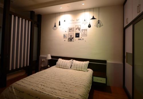 a bedroom with a bed and some pictures on the wall at Decozy 3.0 Semi-D in Ipoh