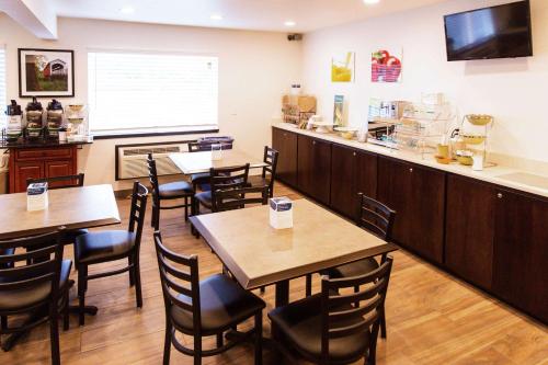 ein Restaurant mit Tischen und Stühlen und eine Bar in der Unterkunft Cottage Grove Inn in Cottage Grove