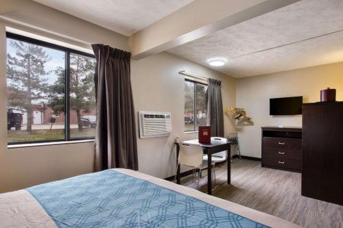 a bedroom with a bed, chair and a window at Econo Lodge Olathe - Kansas City in Olathe