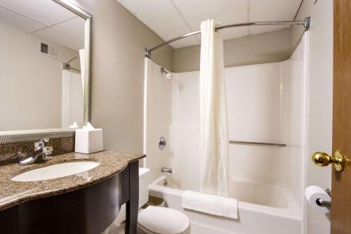 uma casa de banho com um lavatório, um WC e um chuveiro em Econo Lodge Olathe - Kansas City em Olathe