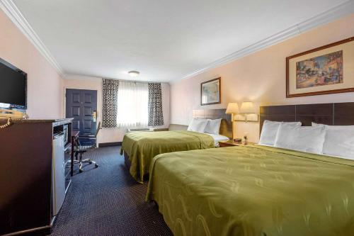 a hotel room with two beds and a flat screen tv at Quality Inn Lomita-Los Angeles South Bay in Lomita