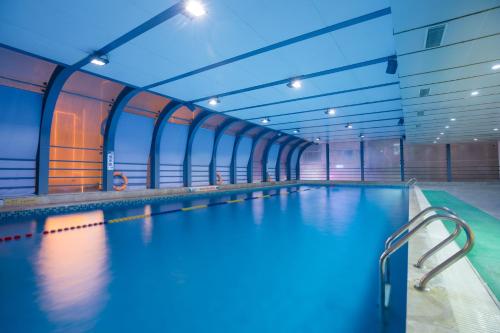 a large indoor swimming pool in a building at Jinling Grand Hotel in Hefei