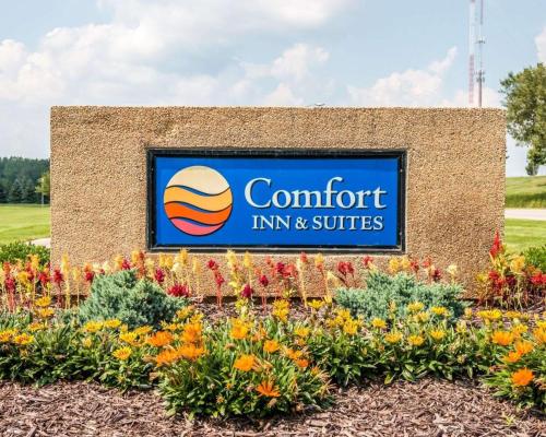 a sign for a comfort inn and suites with flowers at Comfort Inn & Suites and Conference Center in Mount Pleasant