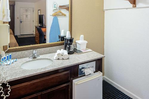 a bathroom with a sink and a mirror at Rodeway Inn at Nevada State Capitol Carson City in Carson City