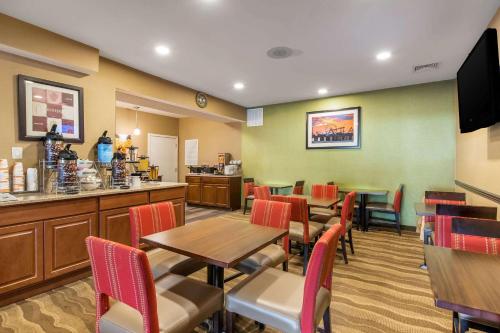 a restaurant with tables and chairs and a bar at Comfort Suites Atlantic City North in Absecon