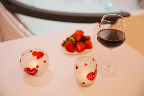 a glass of red wine and a plate of strawberries at B&B Vistamareblu in San Foca