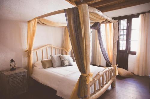 1 dormitorio con cama con dosel y cortinas en The Iskemleci Guest House en Lefkosa Turk