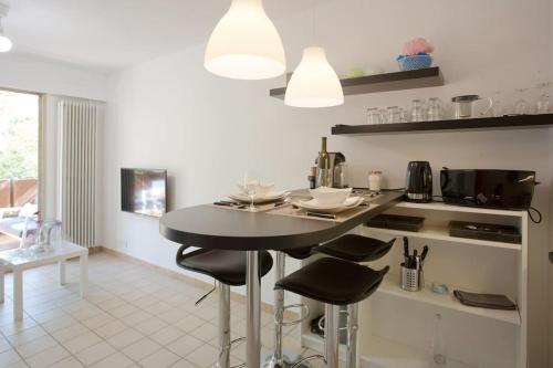a kitchen with a table and chairs in a room at Dans un écrin de verdure in Hyères