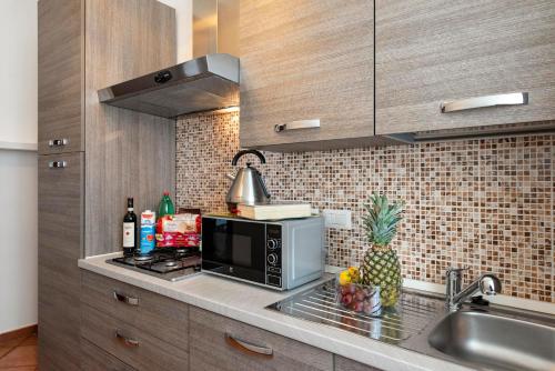 a kitchen with a microwave and a pineapple on a counter at Veneto Prestige Apartment in Rome