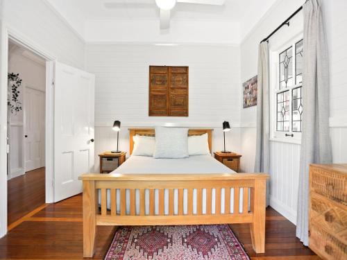 a bedroom with a bed and two windows at Beluso in Byron Bay