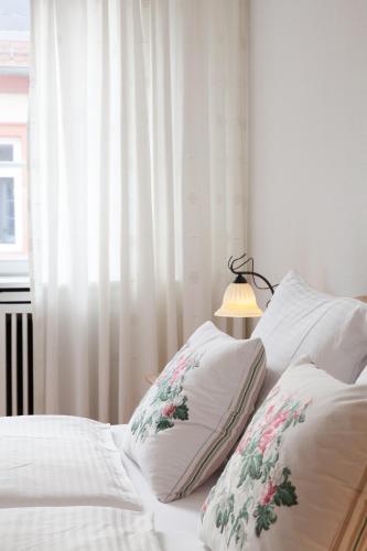 a bed with two pillows and a lamp next to a window at Heidelberg Apheartments in Heidelberg