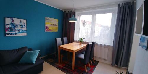 a dining room with a wooden table and a window at F3 - "Gemütlich mit Kunst" in Dresden