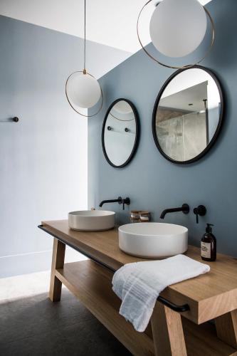 une salle de bain avec deux lavabos et deux miroirs dans l'établissement Maison Aribert, à Saint-Martin-dʼUriage