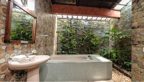 a bathroom with a bath tub and a sink at Flushing Meadows Resorts & Playground in Panglao