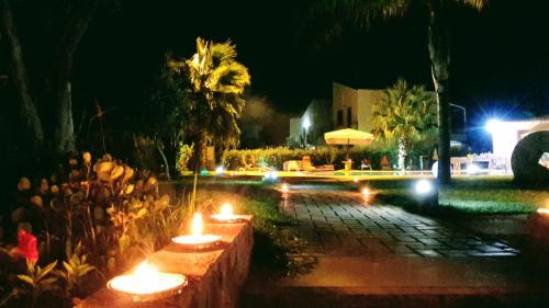 a group of candles in a garden at night at Beb oasi marina in Campofelice di Roccella