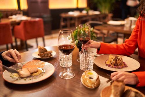 two people sitting at a table with food and wine at BLESS Hotel Madrid - The Leading Hotels of the World in Madrid
