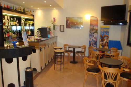 a bar with tables and stools in a restaurant at Hotel Vela Azzurra in Rimini