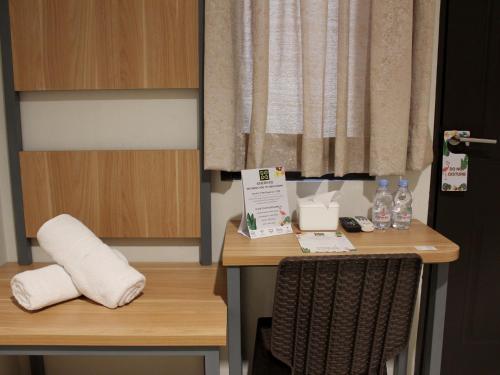 a room with a desk with bottles of water on it at Ghurfati Hotel Mangga Besar in Jakarta