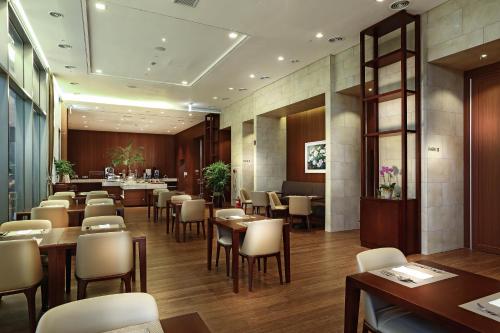 um restaurante com mesas e cadeiras em uma sala em Parksunshine Jeju em Seogwipo