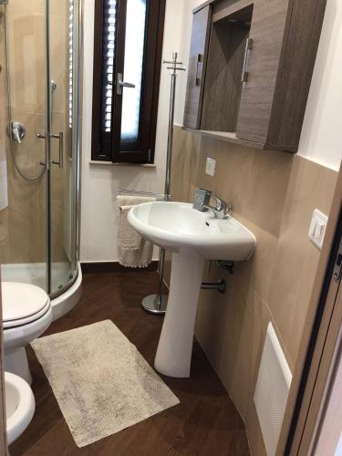 a bathroom with a sink and a shower and a toilet at Beb oasi marina in Campofelice di Roccella