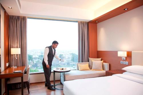 a man standing in a hotel room with a plate of food at Hyatt Regency Amritsar Hotel & Spa in Amritsar