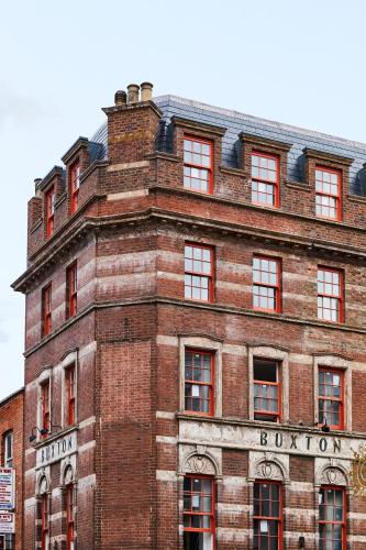 a red brick building with a sign on it at The Buxton in London